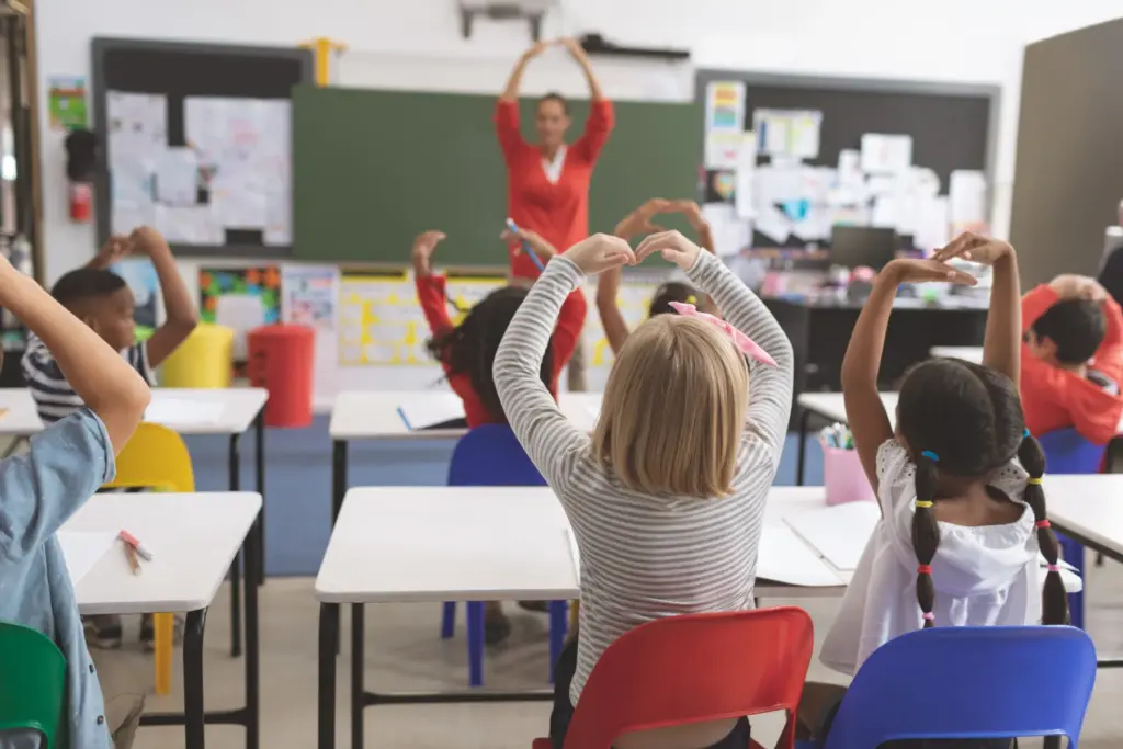 niños-clase-corazon-con-manos-profesora-enseñando