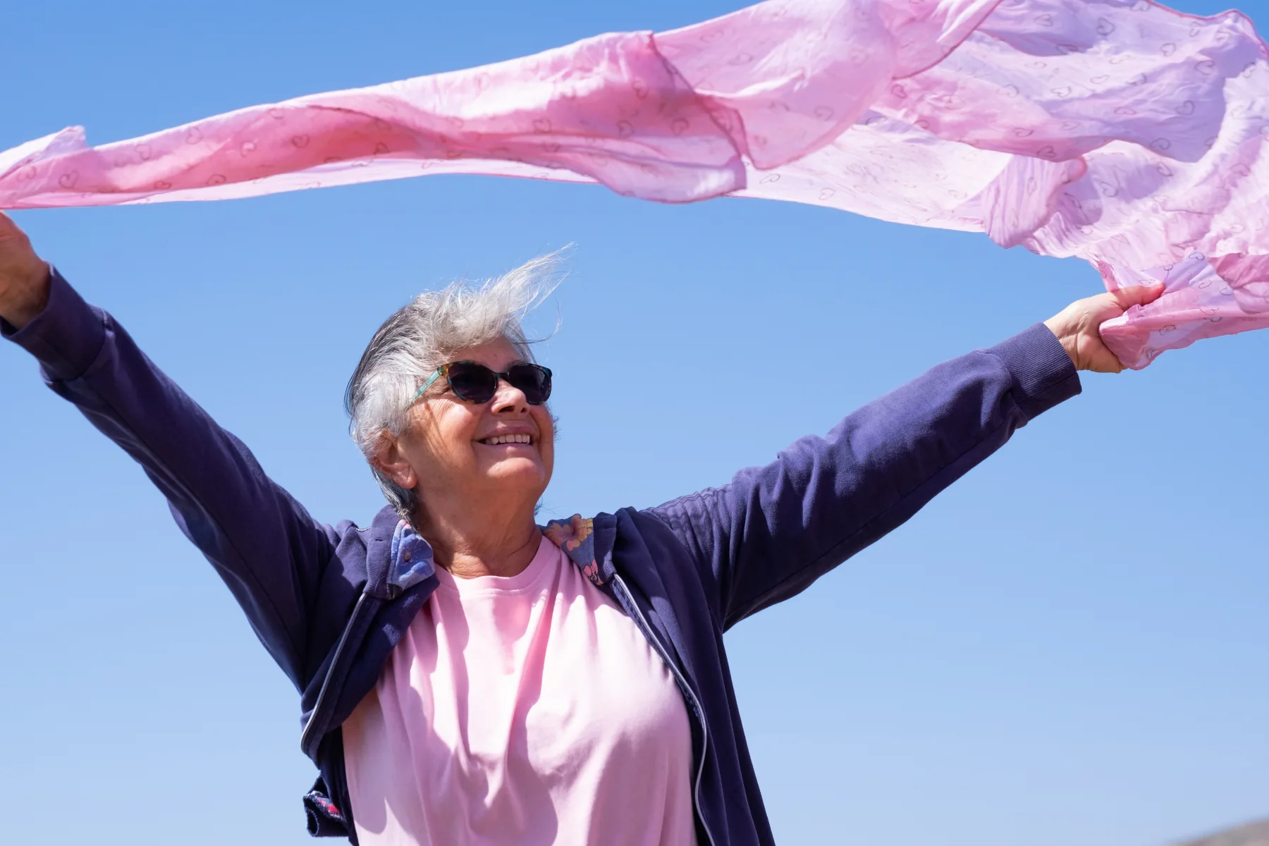 señora-mayor-sonriendo-paño-rosa-ondeando